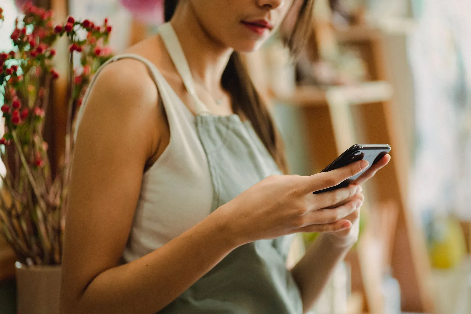 Handen met een smartphone in een winkel