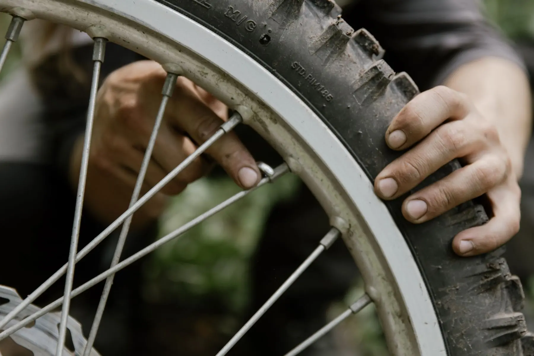 Handen van een monteur aan het achterwiel van een fiets