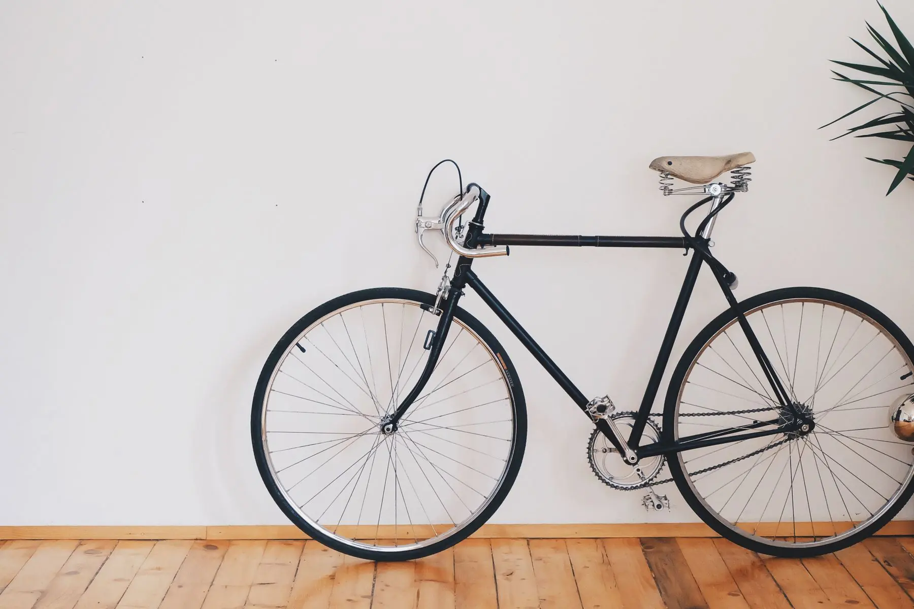 Zwarte stadsfiets tegen een witte muur